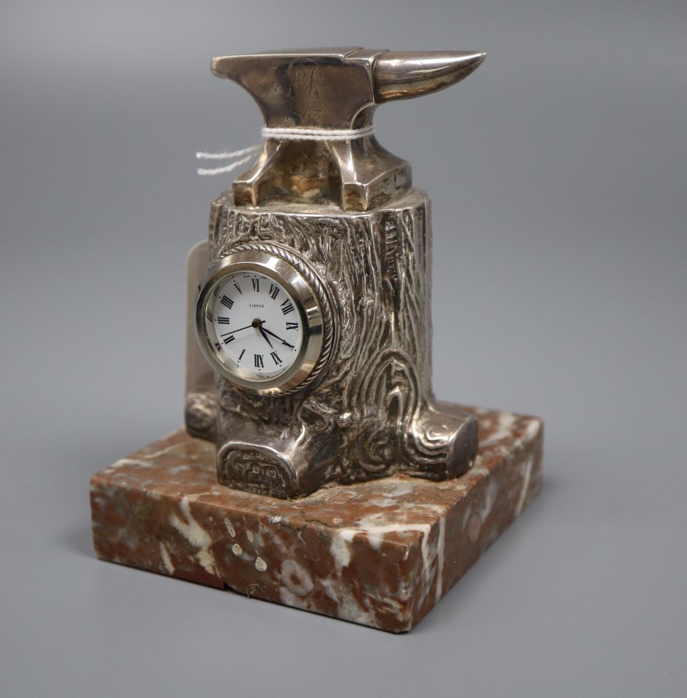 A late Victorian novelty silver mounted timepiece, modelled as an anvil upon a tree stump,